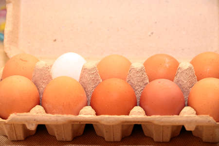 Fresh chicken eggs in a carton on the table for the preparation of food
