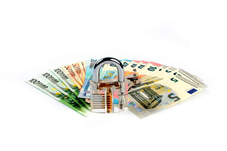 A small pile of euro banknotes and a padlock with keys as an element of the protection of the commercial economic systemの写真素材