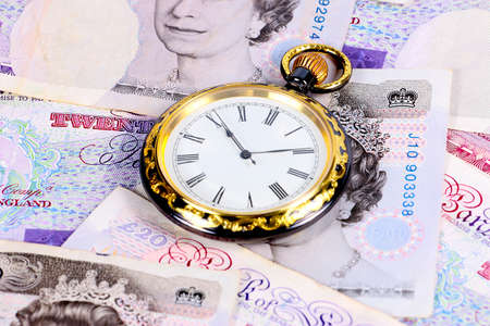 Antique pocket watch on the background of paper money bills