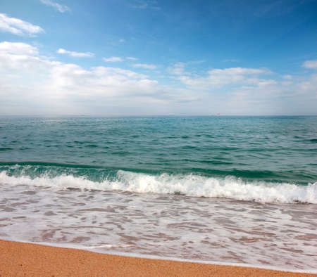 A beautiful ocean surface under a sunny skyline with a sandy beachの写真素材