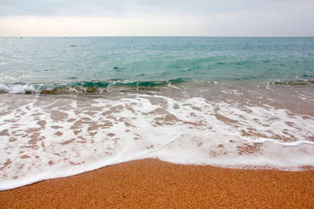 Sandy beach and sea waves as a place for rest and travel