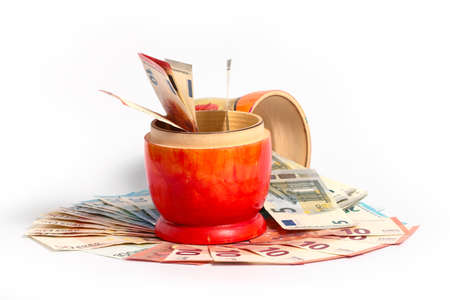 Russian national wooden toy stands on a pile of European paper bills euroの写真素材