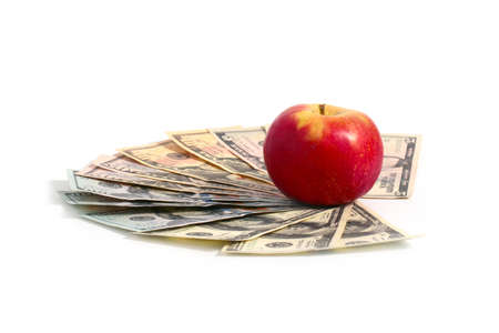 A ripe fresh red apple lies on a pile of American dollarsの写真素材