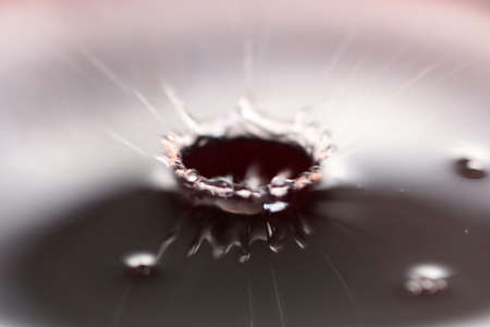 A drop of water on the surface of a liquidの写真素材