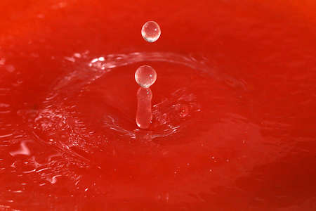 Drops of juice and amazing patterns on the surface of the liquidの写真素材