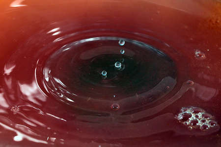 Drops of juice and amazing patterns on the surface of the liquid