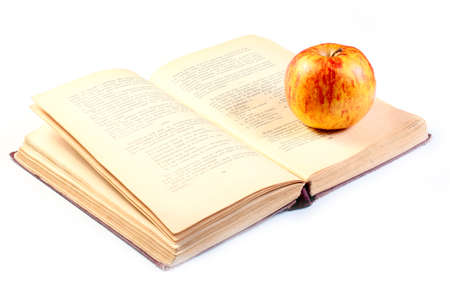 a beautiful ripe apple lies on the pages of the old book