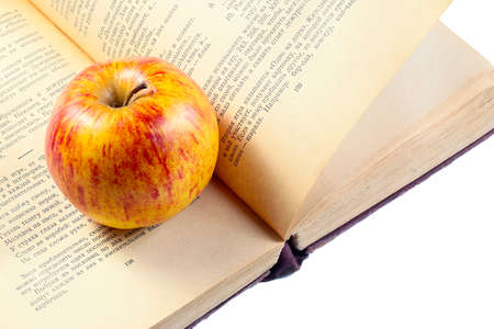 a beautiful ripe apple lies on the pages of the old bookの写真素材