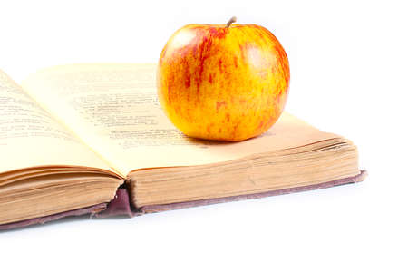 a beautiful ripe apple lies on the pages of the old bookの写真素材