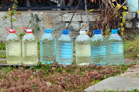 pure drinking water in large plastic bottles on the grass of a country houseの写真素材