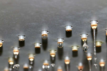 flowing jets and drops of clean water from the shower head nozzles