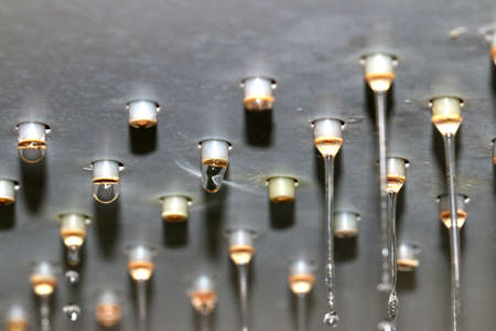 flowing jets and drops of clean water from the shower head nozzlesの写真素材
