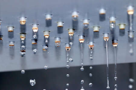 flowing jets and drops of clean water from the shower head nozzles