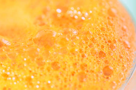 a variety of patterns and air bubbles on the surface of carrot juiceの写真素材