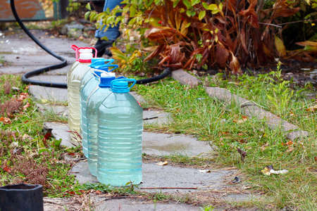 plastic jerricans with clean water in the garden section of the country houseの写真素材