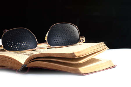 pages of an old book and glasses for correcting eyesightの写真素材