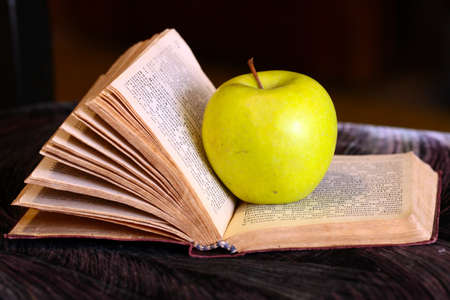 a ripe fresh apple on the pages of an old bookのeditorial素材