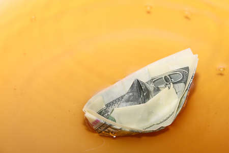 a paper dollar on the surface of a liquidの写真素材