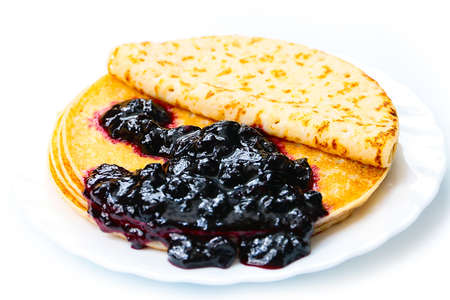 a stack of beautiful pancakes and a bunch of fresh jamの写真素材