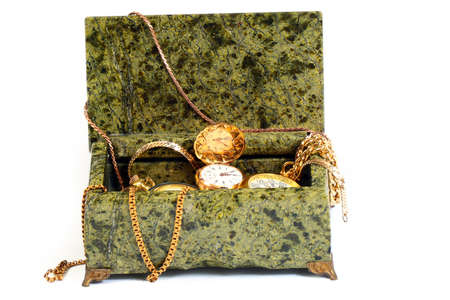 antique pocket watch, gold chains in a box of semi-precious mineral malachite as a symbol of wealth