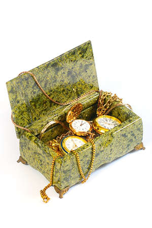 antique pocket watch, gold chains in a box of semi-precious mineral malachite as a symbol of wealthの写真素材