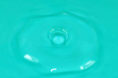 bursts and traces from the impact of a drop of water on the surface of a clean liquidの写真素材