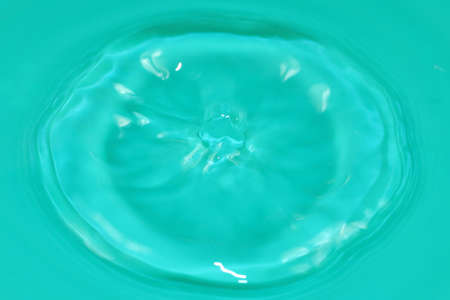 bursts and traces from the impact of a drop of water on the surface of a clean liquidの写真素材