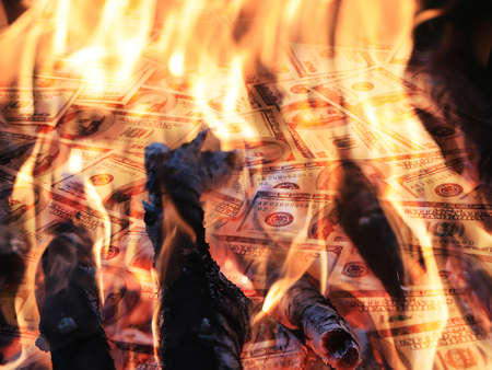 American dollars in a bright flame of fire as an illustration of financial investment risksの写真素材
