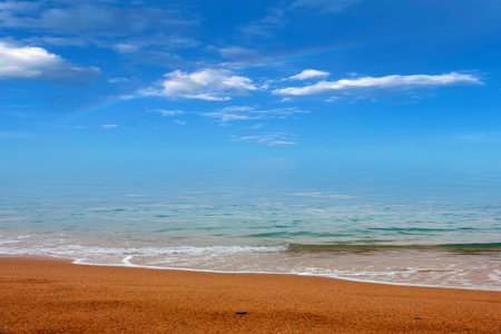 sandy beach and sea waves under a beautiful skyの写真素材