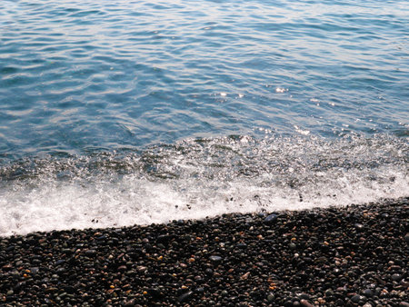 beautiful sea waves fall on the pebble beach