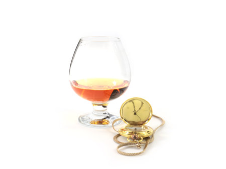 a pocket watch in a gold case and a glass of spiritsの写真素材