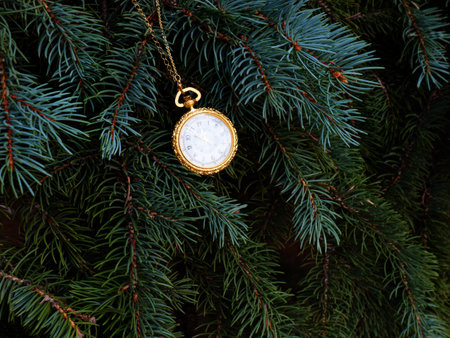 antique pocket watch on a branch of a festive Christmas tree