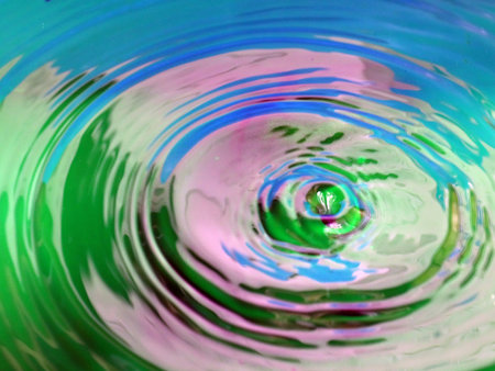 beautiful patterns on the surface of the multicolored liquid after the impact of a drop of waterの写真素材