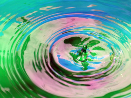 beautiful patterns on the surface of the multicolored liquid after the impact of a drop of water