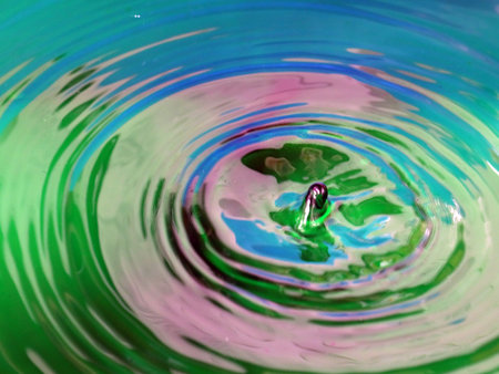 beautiful patterns on the surface of the multicolored liquid after the impact of a drop of waterの写真素材