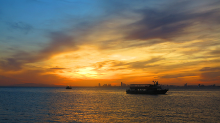 Sunset at Lake with silhouettes small fishing boatの写真素材