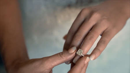 Close up of man and woman hands with wedding rings on blurred background