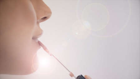 Close up of female lips and syringe on light background. Concept of vaccination