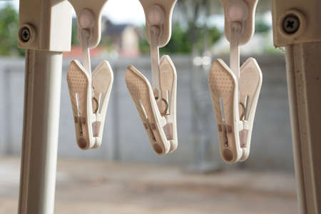 Plastic Clothespins hanging home outdoor on rainy day with selective focus