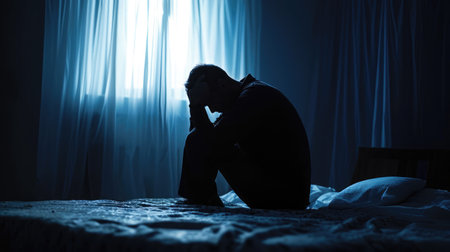 Lonely man silhouette sitting on the bed feeling depressed and stressed in the dark bedroom, Depression and anxiety disorder concept --ar 16:9 --v 6 Job ID: a675a951-3b79-4f1b-b0ea-b9c0869e5938の素材
