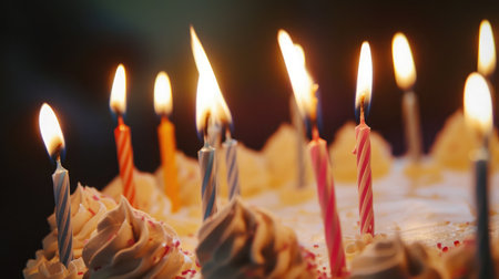 closeup of some unlit candles and just one lit candle after blowing out the cakeの素材