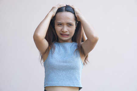 Asian woman having itchy head from dandruff