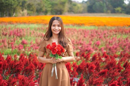 Asian woman smiling happily among beautiful flowers