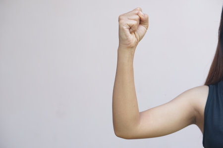 Asian woman raises her fist with confidence