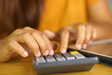Asian women press to work from home Click on the calculator to see profits.の写真素材