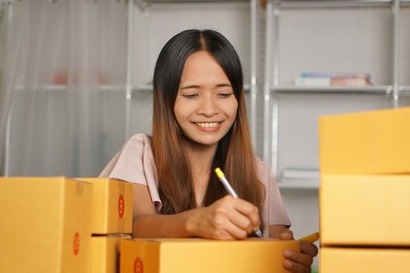 Online retailer checking customer's address on box before sending the goods