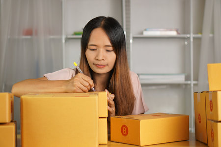 Online retailer checking customer's address on box before sending the goodsの写真素材
