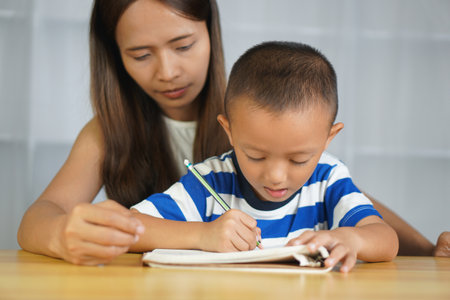 Mother teaching son to do homeworkの写真素材
