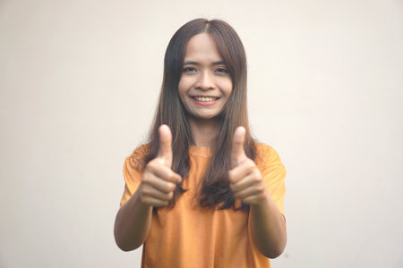 A woman holds up her thumb as a sign of excellence.の写真素材
