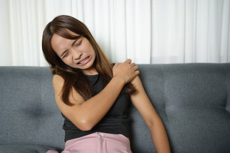 Asian woman has shoulder pain from hard workの写真素材